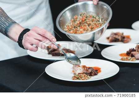 Chief serving homemade bone-in prime rib roast on a white plate 71900185