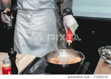 Shrimp on frying pan. Thermal processing of food. Electric cooker in a restaurant 71900191