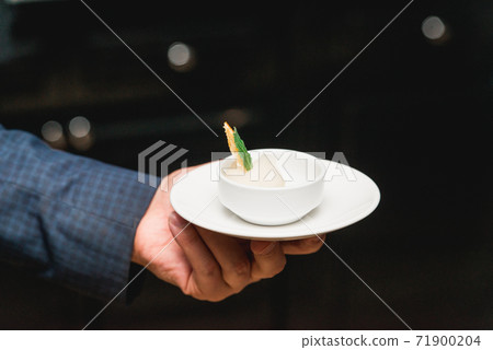 Hand in a suit holds lemon sorbet 71900204