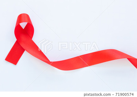 Red ribbon on white fabric background with copy space, symbol for the solidarity of people living with HIV/AIDS, and for the awareness and prevention of drug abuse and drunk driving. Health concept. Red ribbon on white fabric background with copy space, symbol for the solidarity of people living with HIV/AIDS, and for the awareness and prevention of drug abuse and drunk driving. Health concept. 71900574