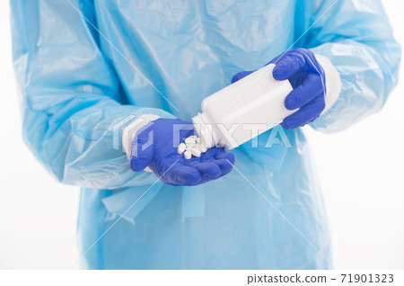doctor epidemiologist hold vitamin pills jar in hand wearing safety protective costume  71901323