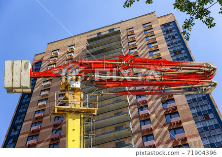 Construction concrete pump (pump truck ) with multi-storey building under construction (new residential complex) on the background, Moscow, Russia 71904396
