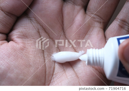 close up of person hand with face cream close up of person hand with face cream 71904716
