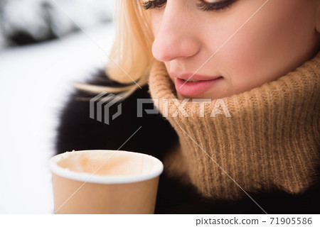 Portrait of european style fashionable woman drinking coffee in winter park. Portrait of european style fashionable woman drinking coffee in winter park. 71905586