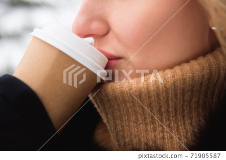 Portrait of european style fashionable woman drinking coffee in winter park. Portrait of european style fashionable woman drinking coffee in winter park. 71905587