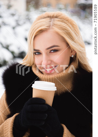 Portrait of european style fashionable woman drinking coffee in winter park. Portrait of european style fashionable woman drinking coffee in winter park. 71905589