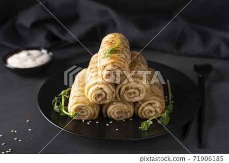 homemade pancakes with meat filling on a black plate 71906185