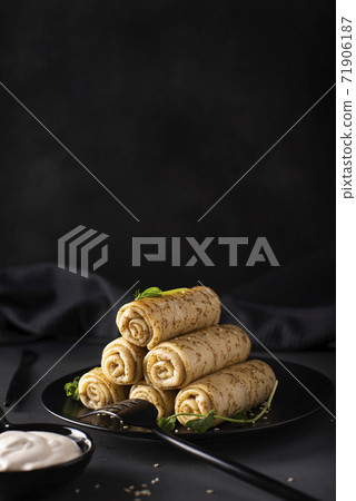 homemade pancakes with meat filling on a black plate 71906187