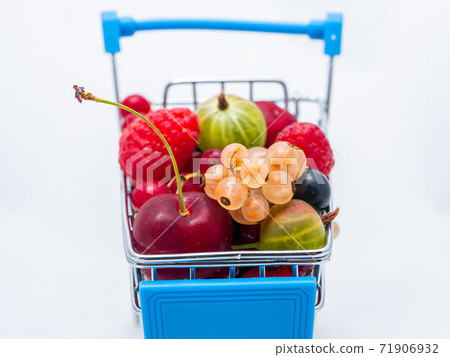 Mini grocery cart filled with fresh vitamin berries isolated on white background Mini grocery cart filled with fresh vitamin berries isolated on white background 71906932