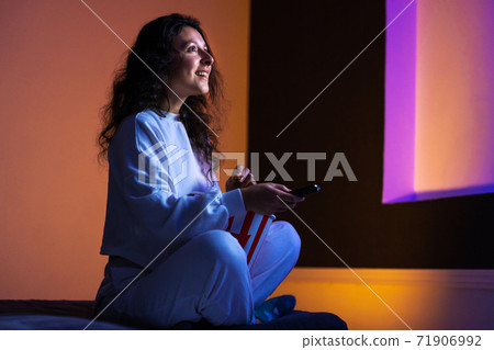 person watches a movie sitting on the couch with a bucket of popcorn person watches a movie sitting on the couch with a bucket of popcorn 71906992