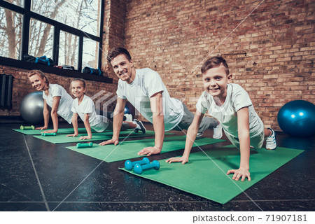 Young family performing push ups from the floor. Young family performing push ups from the floor. 71907181