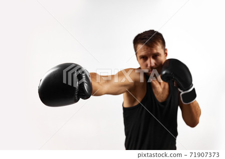 sporty man in black boxing gloves punching 71907373