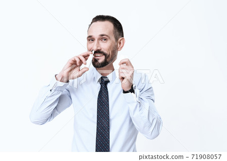 Man smiles and closes his nose on a white. Man smiles and closes his nose on a white. 71908057