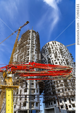 Construction concrete pump (pump truck) with multi-storey building under construction with scaffolding (new residential complex) on the background, Moscow, Russia 71908181