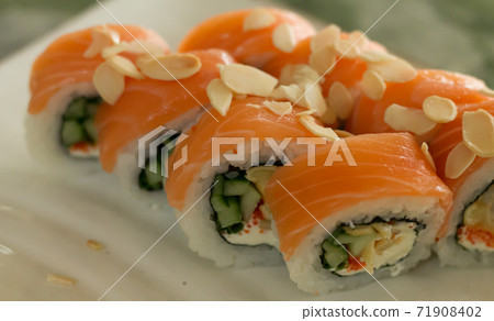 Philadelphia sushi rolls with almond nut decoration closeup Philadelphia sushi rolls with almond nut decoration closeup 71908402