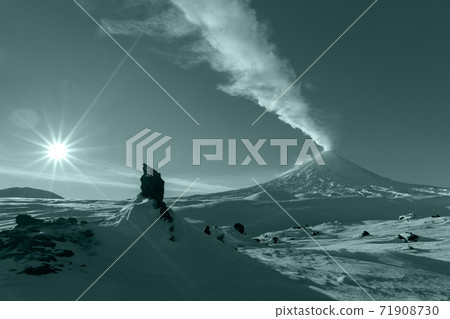 Winter eruption active volcano, plume ash, gas from crater. Volcanic landscape coloring in trend Tidewater Green color of year 2021 Winter eruption active volcano, plume ash, gas from crater. Volcanic landscape coloring in trend Tidewater Green color of year 2021 71908730