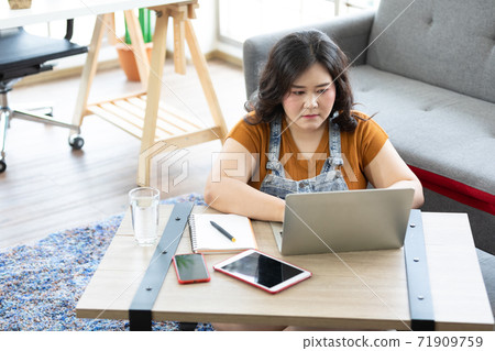 chubby woman typing on laptop computer and thinking about work or study chubby woman typing on laptop computer and thinking about work or study 71909759