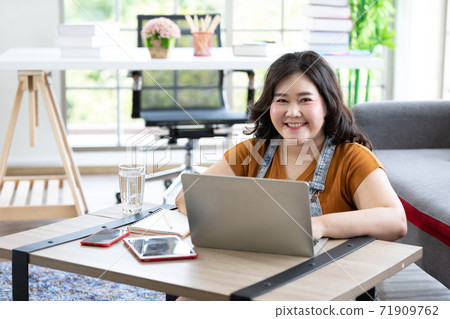 Portrait smile chubby woman works from home and studying with computer laptop 71909762