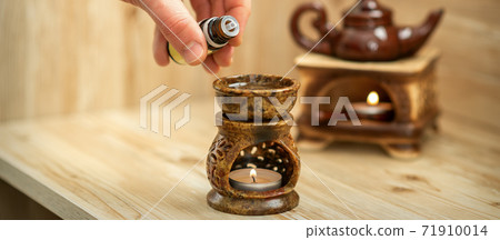 Hand pours essential oil to diffuser 71910014