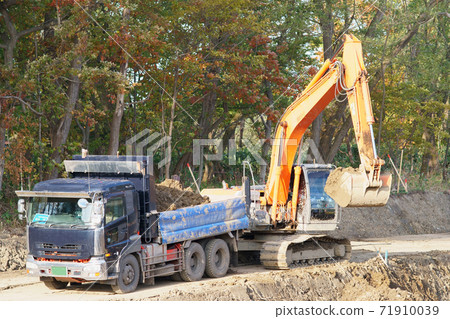 Stacking earth and sand on a dump truck with a power shovel at a waterway construction site 71910039