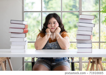 asian chubby woman thinking about something with many textbook 71910085
