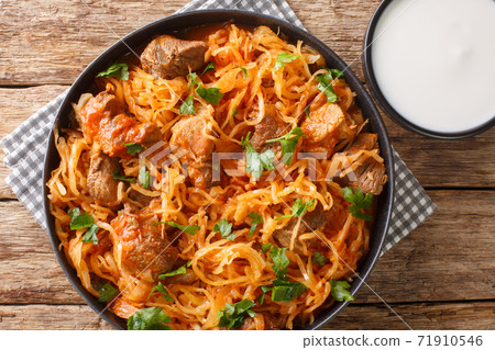 Sauerkraut stew with pork and paprika close-up in a plate. horizontal top view 71910546