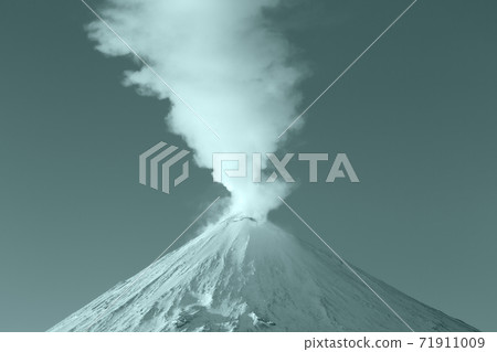 Winter eruption active volcano, plume from crater steam, gas, ashes. Volcanic landscape coloring in trend Tidewater Green color of year 2021 Winter eruption active volcano, plume from crater steam, gas, ashes. Volcanic landscape coloring in trend Tidewater Green color of year 2021 71911009
