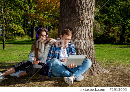 guy with girl with gadgets in the park 71913003