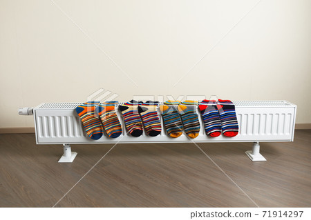 colorful socks are being dry on the radiator 71914297