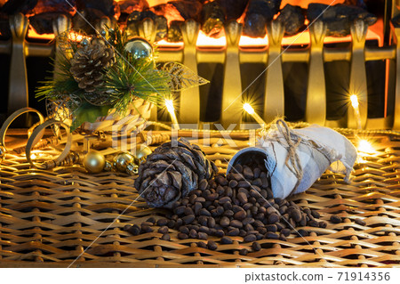Cone and pine nuts on the braided surface. Christmas tree and lights. Cone and pine nuts on the braided surface. Christmas tree and lights. 71914356