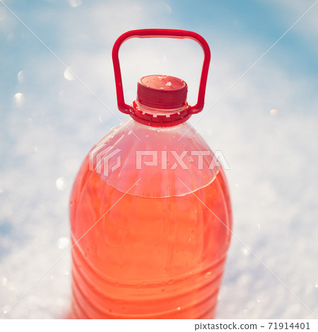bottle with non-freezing windshield washer fluid, snow background bottle with non-freezing windshield washer fluid, snow background 71914401