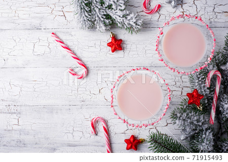Pink peppermint martini with candy cane rim Pink peppermint martini with candy cane rim 71915493
