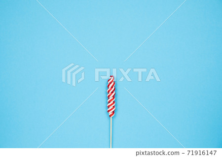 Christmas red candy cane on blue background. Merry Christmas sweets and Minimal Happy New Year concept Christmas red candy cane on blue background. Merry Christmas sweets and Minimal Happy New Year concept 71916147