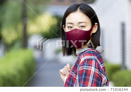 Young woman wearing a cloth mask 71916244