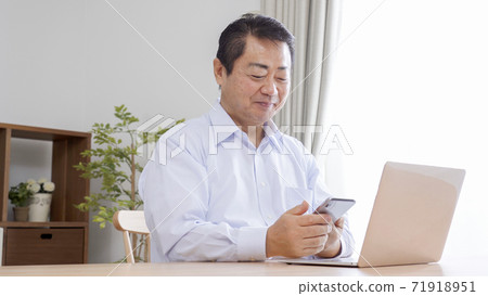 Middle-aged and older businessmen teleworking at home Middle-aged and older businessmen teleworking at home 71918951
