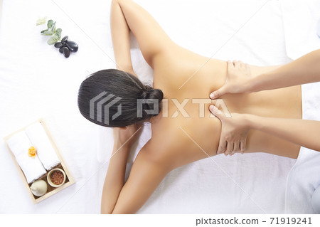 Woman receiving back massage 71919241
