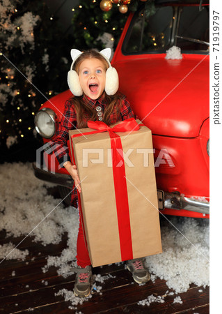 The girl is happy with a big New Year's gift. The girl is happy with a big New Year's gift. 71919797