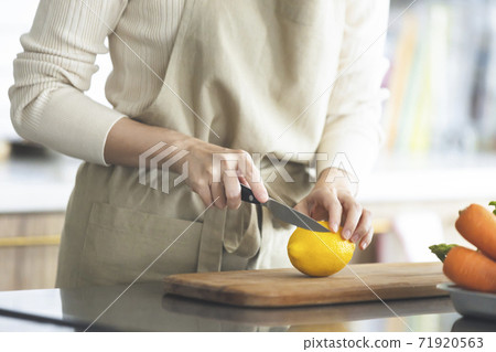 Woman cutting lemon in the kitchen 71920563
