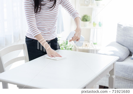 Woman disinfecting table (no face) Woman disinfecting table (no face) 71921680