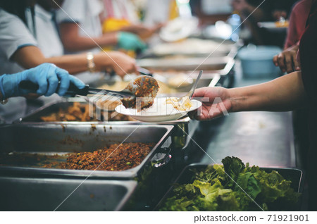 Starving homeless people receive food from volunteers who serve humane 71921901