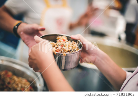 Starving homeless people receive food from volunteers who serve humane Starving homeless people receive food from volunteers who serve humane 71921902