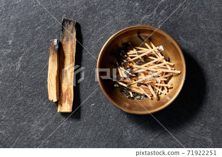 palo santo sticks and cup with burnt matches 71922251