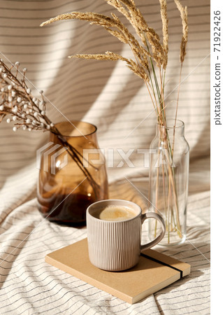 cup of coffee, diary and dried flowers in vases cup of coffee, diary and dried flowers in vases 71922426