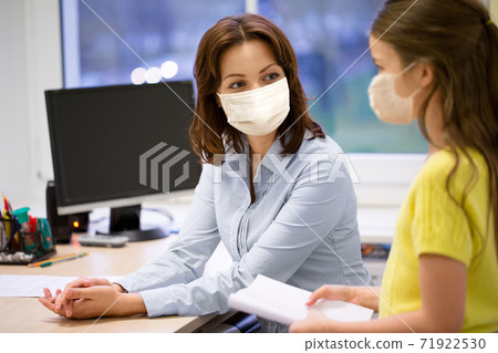 teacher and student girl in masks at school teacher and student girl in masks at school 71922530
