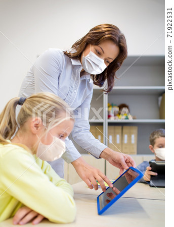 school teacher and student in masks with tablet pc 71922531