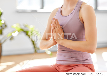 woman meditating in lotus pose at yoga studio 71922739
