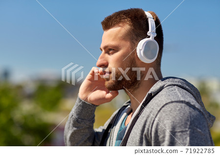 man in headphones listening to music outdoors 71922785