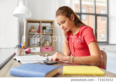 student girl counting on calculator at home student girl counting on calculator at home 71923032