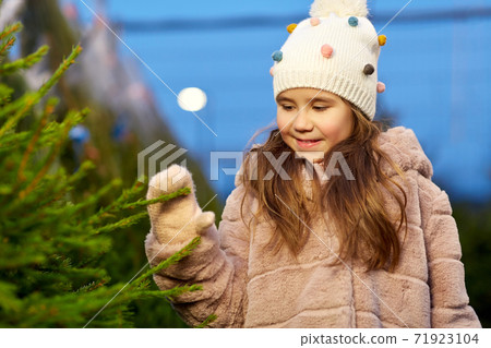 little girl choosing christmas tree at market little girl choosing christmas tree at market 71923104