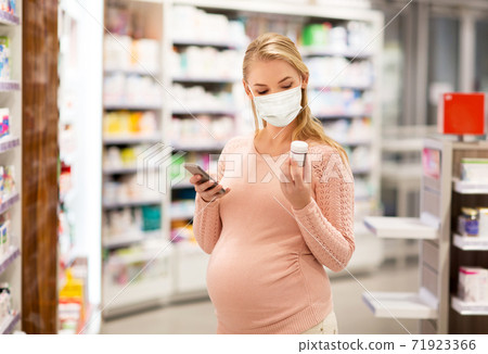 pregnant woman in mask with medicine at pharmacy pregnant woman in mask with medicine at pharmacy 71923366